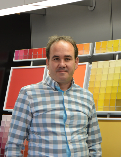 owner of the painting company in a white blue and grey button shirt